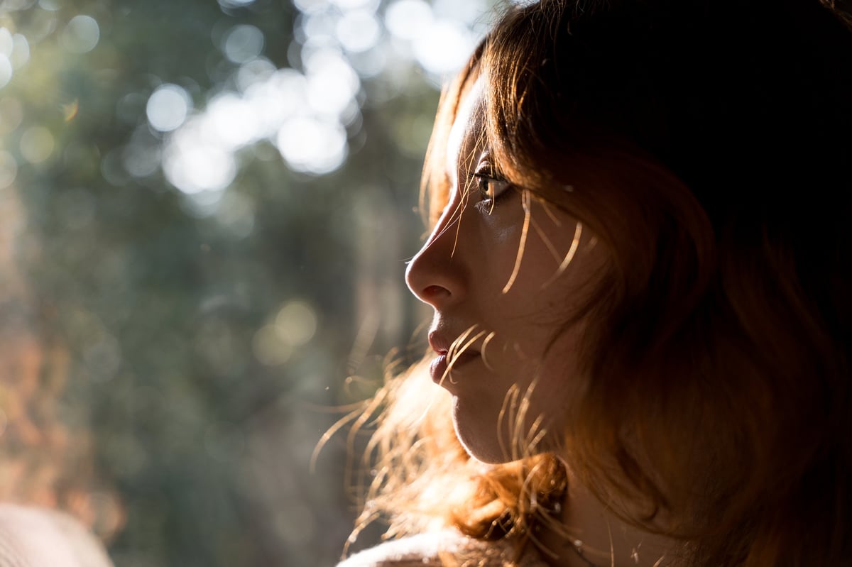 Thoughtful woman looking out the window, her face calm and focused