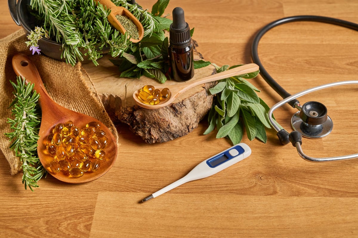 Jars of natural medicines, supplements, and medicinal herbs on a wooden background
